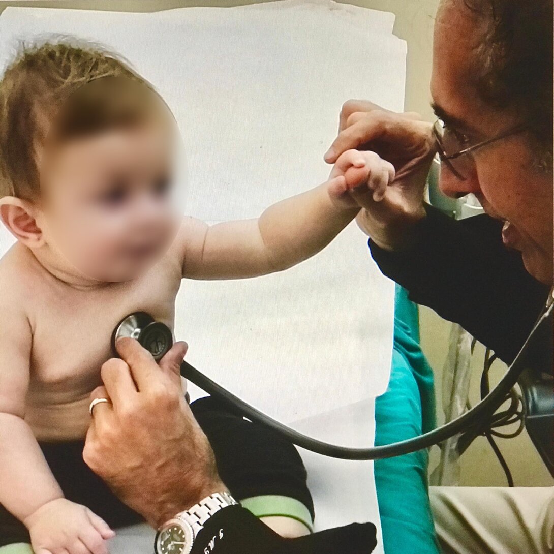 Cardiologo pediatrico che ausculta il cuore di un bambino