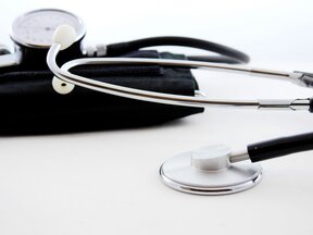 Cardiologo che illustra a un paziente un percorso interventistico su un monitor