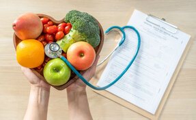 Incontro tra paziente e nutrizionista con schema alimentare sul tavolo